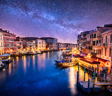 View of Grand Canal di Venezia from Ponte di Rialto at night with milkyway in the sky. Venice. Italy