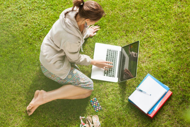 istock Female student using laptop with books at the park 846558744