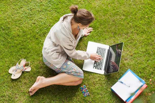 istock Female student using laptop with books at the park 846558754
