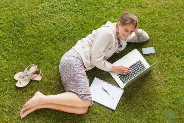 istock Female student using laptop with books at the park 846558770