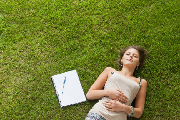 istock Female student resting on grass at the park 846558788