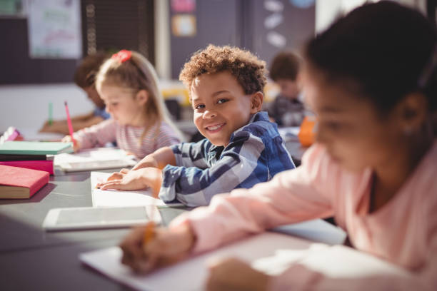 istock Portrait of smiling schoolboy doing his homework in classroom 846567560