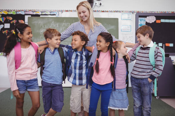 istock Happy teacher standing with schoolkid in classroom 846567814