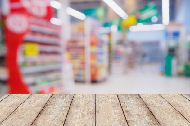 istock Wood table with Abstract blurred supermarket aisle and shelves 846584288