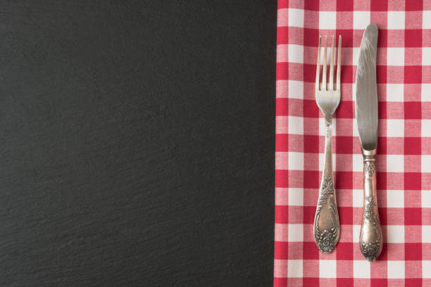 istock Silverware with red checkered towel and empty tag on blackc slate background. Top view. Menu card for restaurants. 846586786