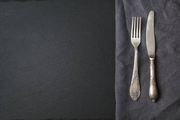 istock Rustic gray linen napkin, silverware and black slate dish with copy space for your menu or recipe. Menu card for restaurants. Top view. 846586790