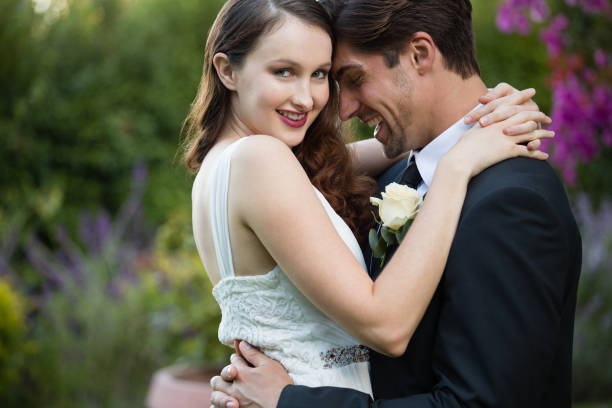 istock Happy bride embracing bridegroom while standing in park 846590714