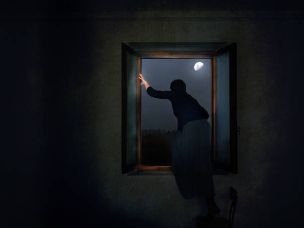 Sad woman looking out of the window in loft apartment