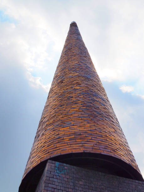 Large brick cone dome pyramid heading up to the cloud background, vertical