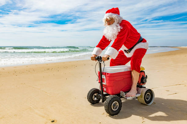 istock Santa Claus Riding a Motorised Esky Cooler on the Beach 846599256