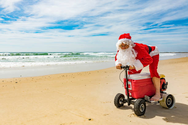 istock Santa Claus Riding a Motorised Esky Cooler on the Beach 846599268