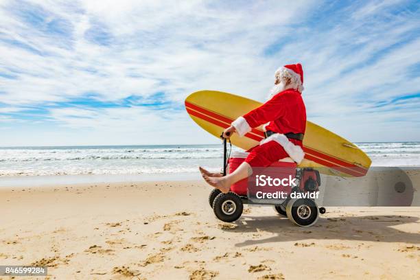 Santa Claus Doing A Wheelie On A Motorised Esky Cooler On The Beach Stock Photo - Download Image Now