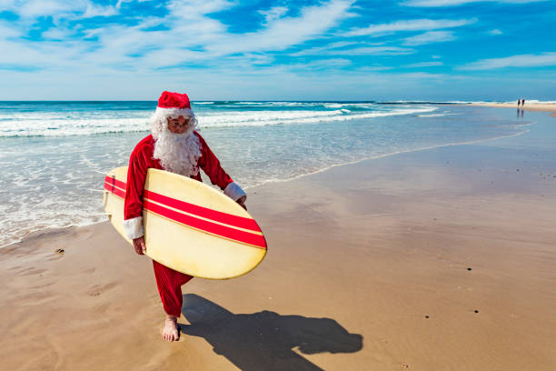 istock Surfing Santa Claus Running on the Beach with a Surfboard 846599308