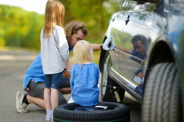 istock Happy family changing a car wheel 846599946
