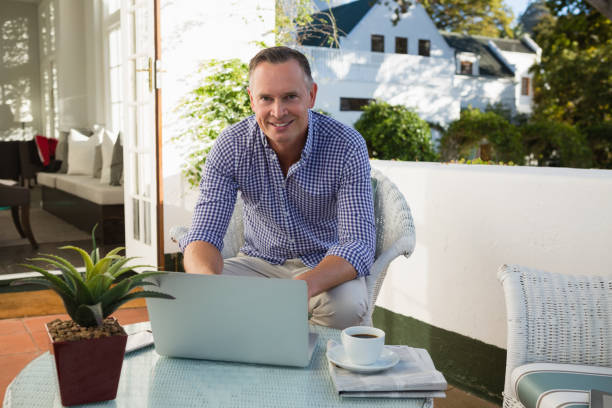 istock Mature businessman using laptop while sitting at outdoor cafe 846605470