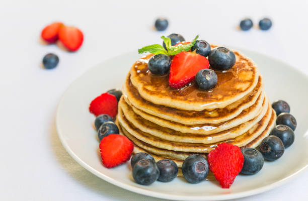 istock American pancakes with blueberries, strawberries, and honey against white background 846609708