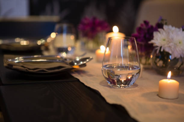 istock Close up of drinking glass by lit candles on dining table 846616856
