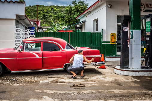 Matanzas: HDR - Cuban man control his american red Pontiac classic car on the gas station in Matanzas Cuba - Serie Cuba Reportage