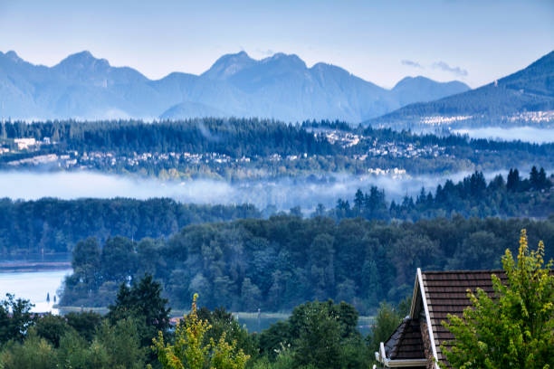 Distant view of mountains and islands with forest in foreground, with a sunrise sky taken from Orcas Island in the San Juans