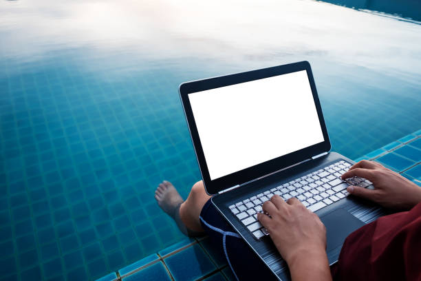 istock Laptop computer, a man using computer laptop, at poolside with dipping legs in the water. Clipping path computer screen 846628832