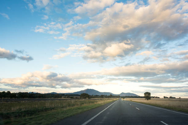 istock Country road leading towards mountains with blue cloudy sky 846629828