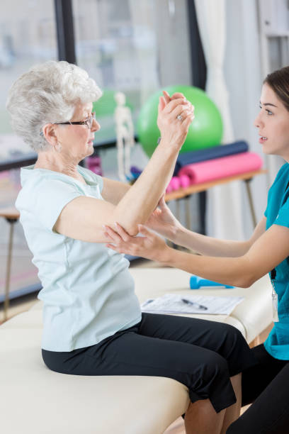 istock Physical therapist helps woman lift arms 846633170