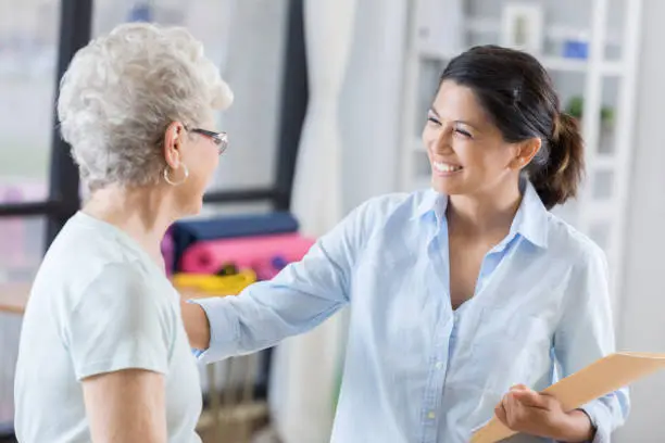 Photo of Confident female chiropractor talks with new patient