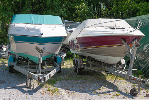 two motor boats on trailers in parking