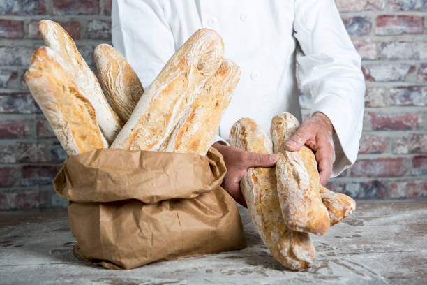 istock baker holding  traditional bread french baguettes 846643194