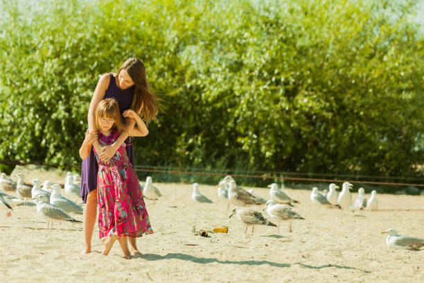 istock Mother and daughter on beach near boat 846646564