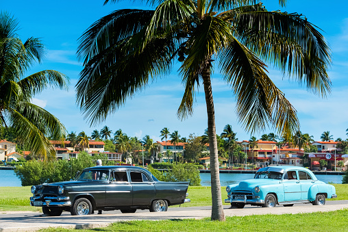 Varadero: Cuban man on his american black Dodge Kingsman classic car parked on the Malecon near the beach in Varadero Cuba - Serie Cuba Reportage