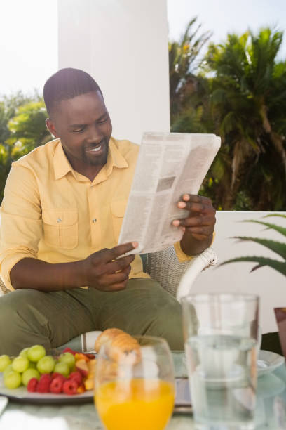 istock Happy young man reading newspaper at cafe 846658026