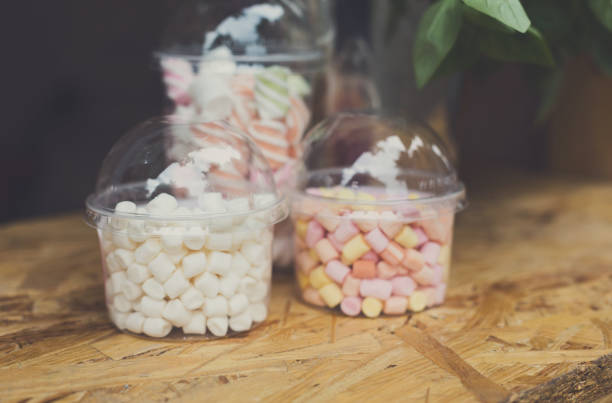 Desserts choice. Marshmallow chewing candies in glass jars on counter bar. Traditional american sweets for sale, closeup
