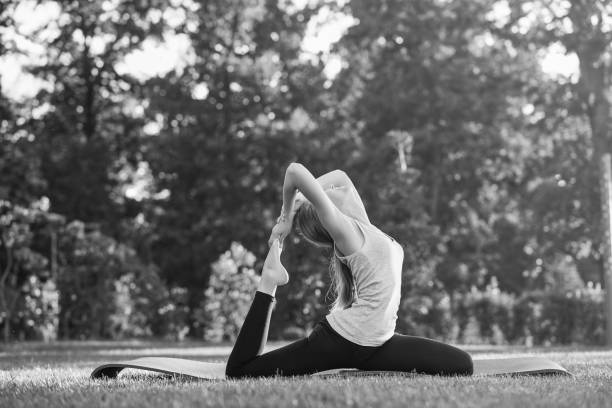 istock Young woman practicing yoga outdoors at the park 846667484