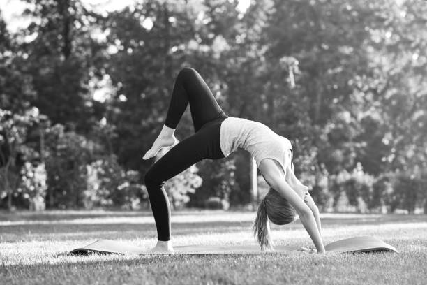istock Young woman practicing yoga outdoors at the park 846667526