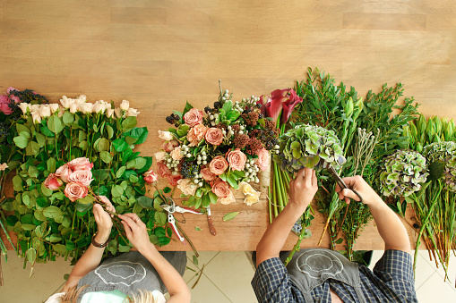 Floreria y asistente en Florerias tienda hacen ramo color de rosa, vista superior de la tabla photo