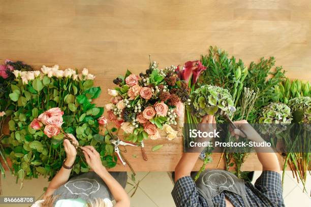 Florist And Assistant In Flower Shop Delivery Make Rose Bouquet Table Top View Stock Photo - Download Image Now