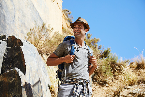 Happy guy in hat on a hike, smiling