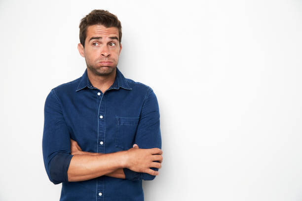 Anxious guy Anxious guy in blue shirt in studio, looking away edgy man stock pictures, royalty-free photos & images