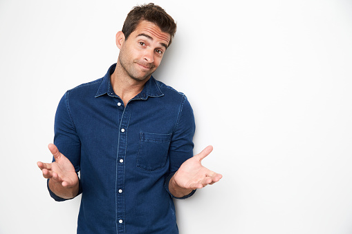 Handsome guy shrugging in studio, portrait