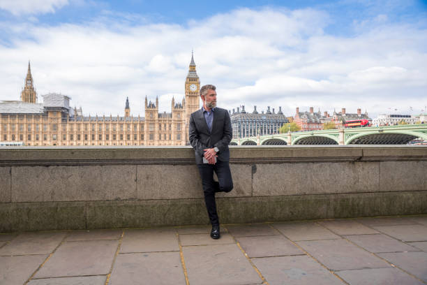 Businessman standing on the promenade Handsome businessman standing in front of the Palace of Westminster and Westminster bridge westminster bridge stock pictures, royalty-free photos & images