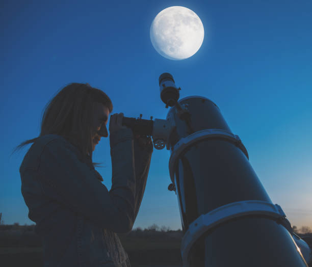 istock Girl looking at the Moon through a telescope. 846692466