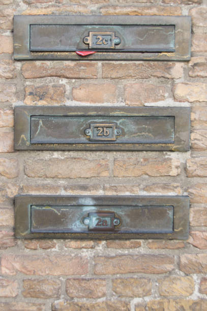 istock three vintage brass letterboxes for mail, post, in brick wall of appartement, 846699730