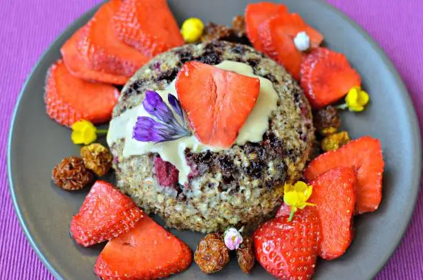 Gluten-free and vegan chocolate and raspberry bowlcake, topped with cashew butter, fresh strawberries and dried inca berries.