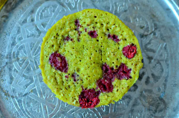 Pistachio, raspberry and white chocolate bowlcake on Moroccan silver plate