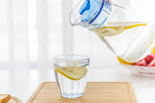 istock Pouring water from filter jug into glass in the kitchen 846704864
