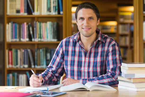 istock Mature student writing notes at desk in the library 846707470