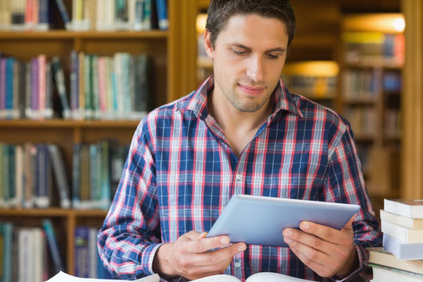 istock Mature student looking at tablet PC in the library 846707572