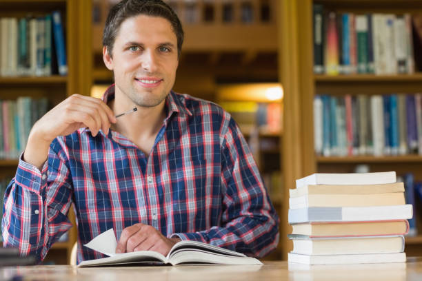 istock Smiling mature student studying at desk in the library 846708110