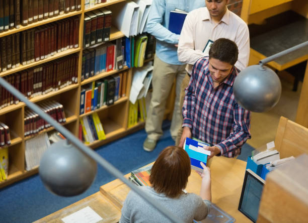 istock Mature students at counter in college library 846710676